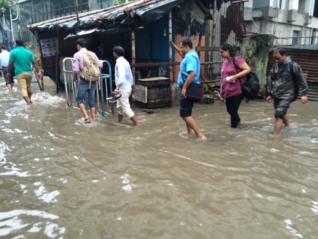 Despite widespread flooding many Kolkata native make the trek to work.