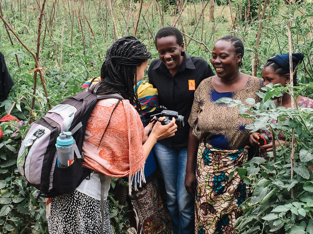 I show Caroline (Sales Associate) and Maria (Solar Sister Entrepreneur) the photo I took of them standing with a customer who uses solar lanterns to plant her tomatoes at night. It now makes sense to all of us why I asked them to stand inside a field of tomatoes.