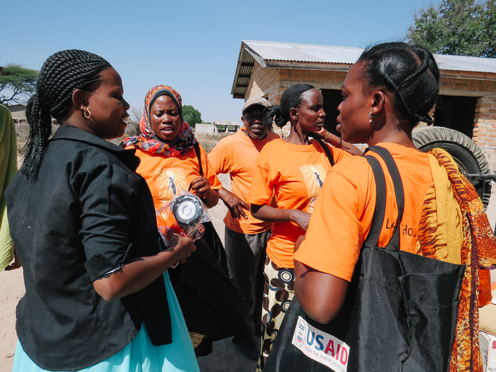 Solar Sister entrepreneurs purchase solar lanterns from sales associate, Regina, as they stock up their inventory for the coming week.