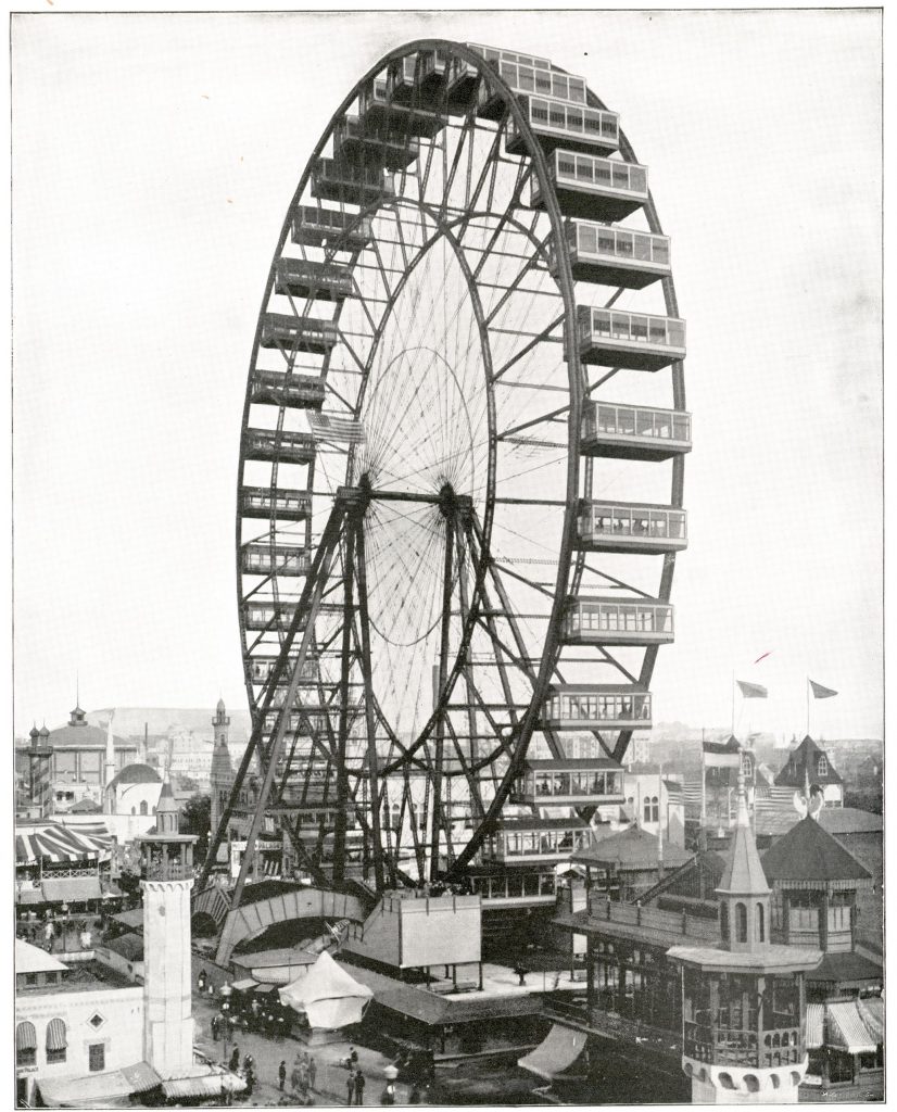 A large ferris wheel towers over many buildings below it