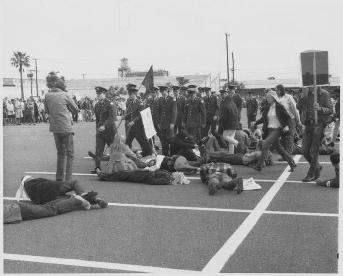 Black-and-white photograph of students and faculty disrupting the End-of-Year President's Review of ROTC. On May 13, 1970, about seventy-five faculty and students protested against the presence of ROTC on campus and disrupted the end-of-the-year President's Review.
