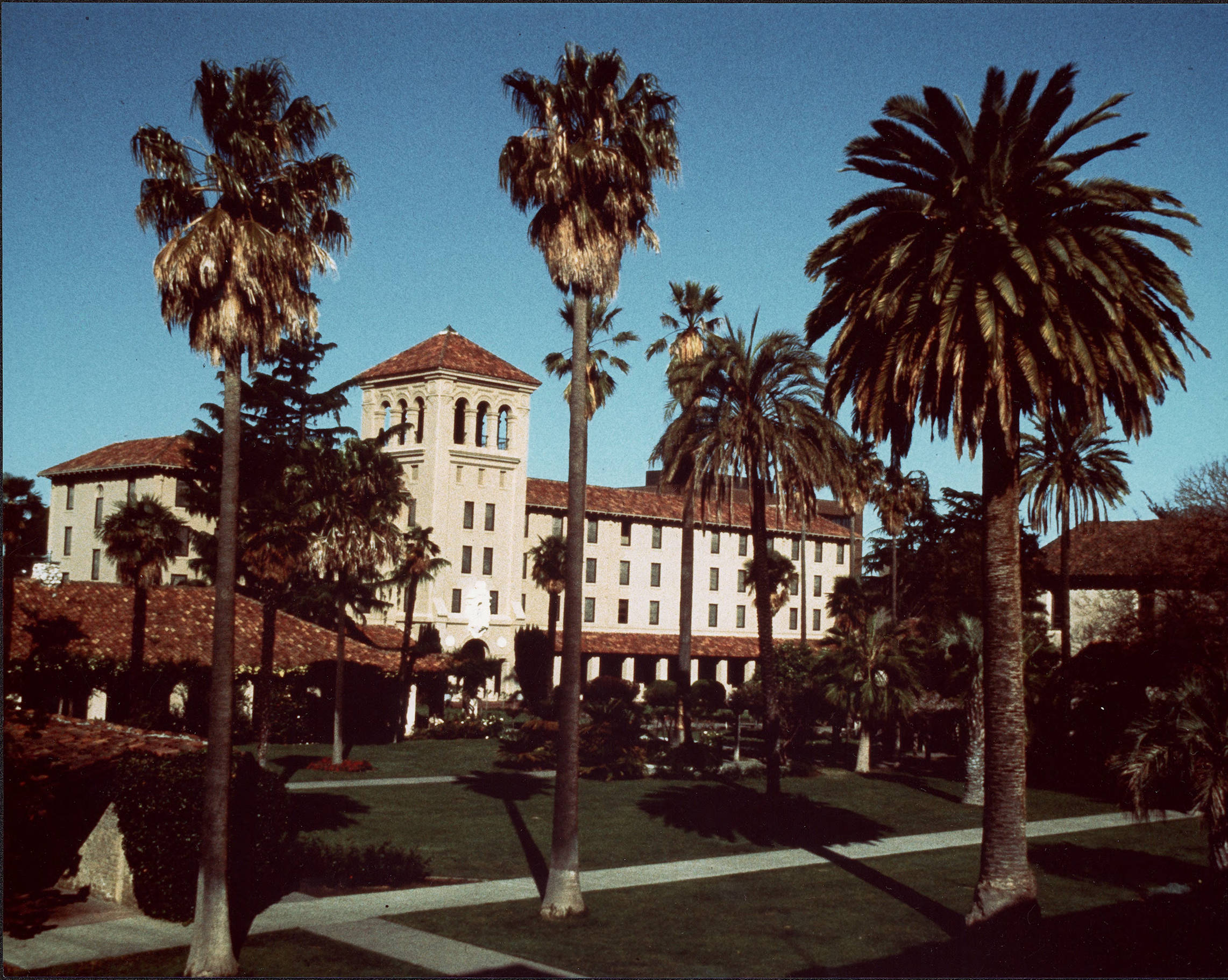 Color photograph of St. Joseph's hall in a lawn with palm trees