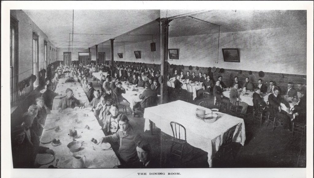 Boys eating in large communal mess hall