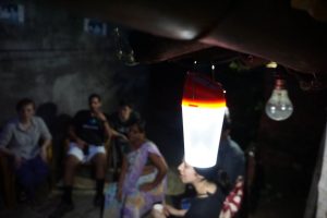 The EG excursion team at Runa's house, using one of Runa's solar lights to be able to see.