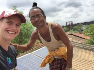A man shows me the rooftop solar panels powering his village's microgrid