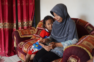 One of Nazava's resellers taking our mobile survey as her daughter gazes up at her.